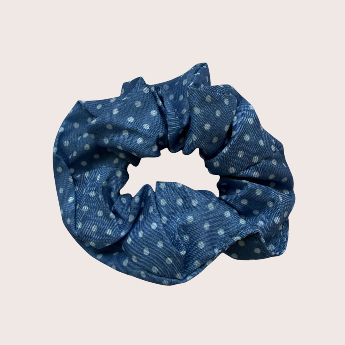 Nitelief blue scrunchie with white polka dot pattern, approximately 8 cm in diameter, soft fabric hair accessory.