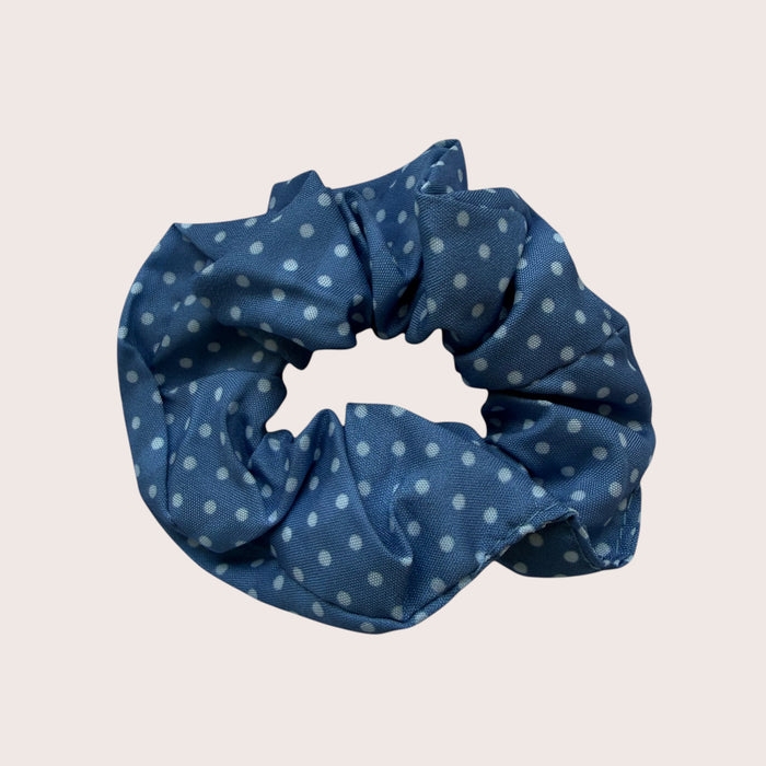 Nitelief blue scrunchie with white polka dot pattern, approximately 8 cm in diameter, soft fabric hair accessory.