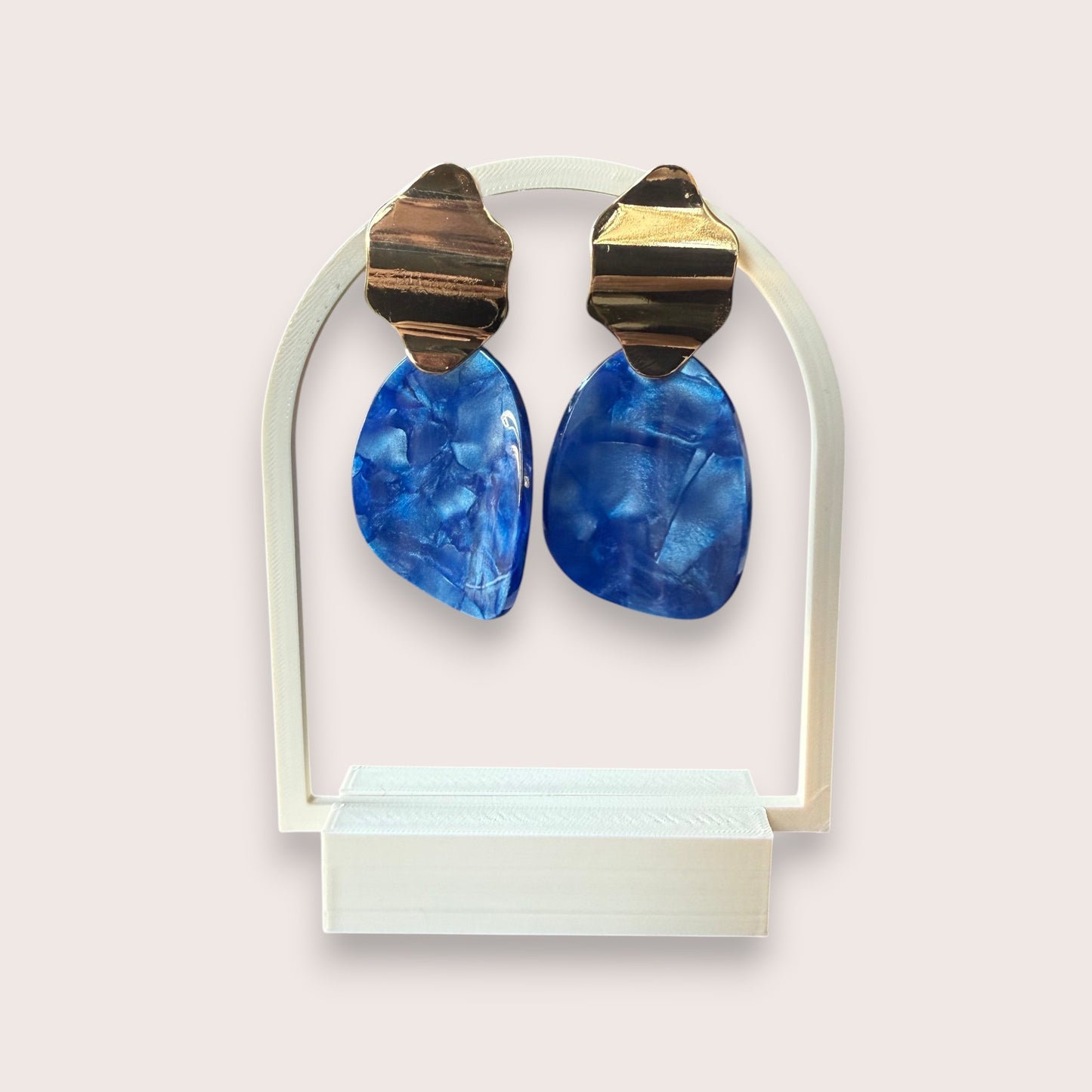 Nitelief CONCEPT retro earrings featuring gold-tone metal tops and blue marbled resin drops on a display stand