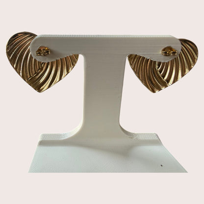 Nitelief CONCEPT golden heart earrings with a ribbed texture displayed on a white stand