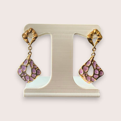 Nitelief CONCEPT Lilas gold-toned drop earrings with unique lilac patterned cut-out details on a white display stand.