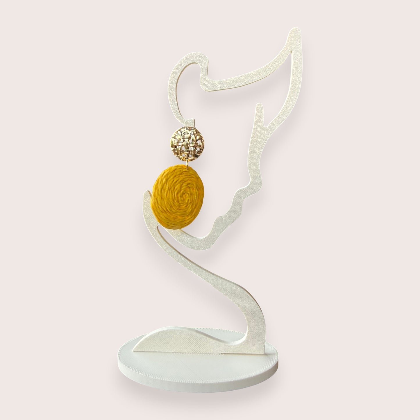 Nitelief CONCEPT Zonnetje raffia earrings featuring a woven gold stud and a round yellow textured raffia drop.