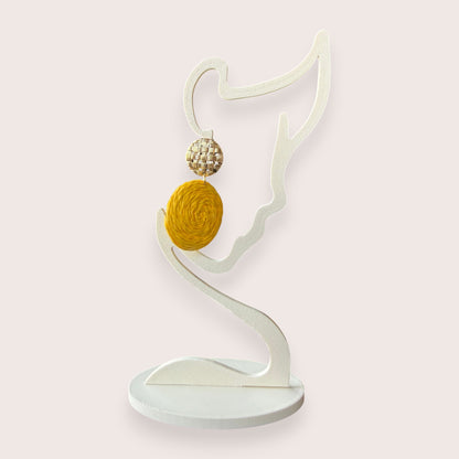 Nitelief CONCEPT Zonnetje raffia earrings featuring a woven gold stud and a round yellow textured raffia drop.