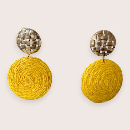 Nitelief CONCEPT Zonnetje earrings featuring round yellow raffia discs suspended from textured gold-tone studs.