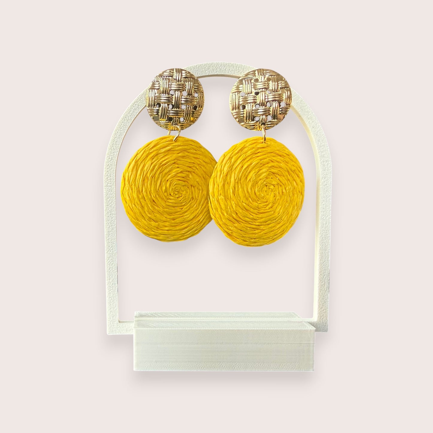 Nitelief CONCEPT Zonnetje earrings featuring round yellow raffia discs and textured gold-tone metal studs