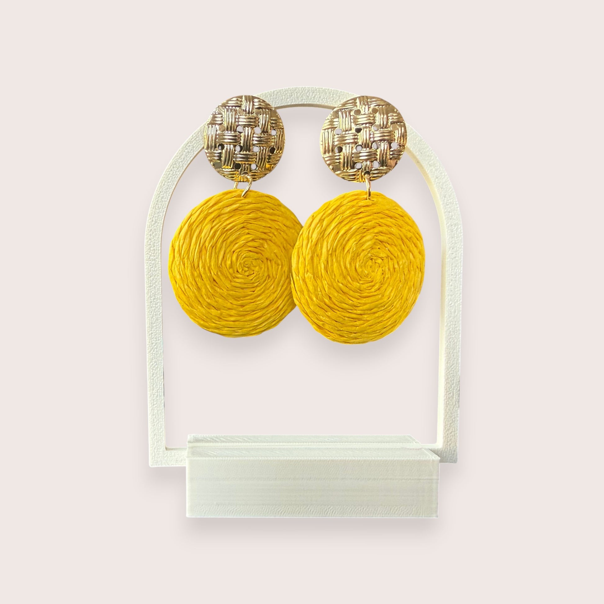 Nitelief CONCEPT Zonnetje earrings featuring round yellow raffia discs and textured gold-tone metal studs