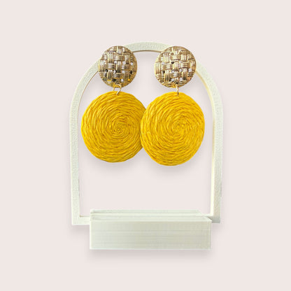 Nitelief CONCEPT Zonnetje earrings featuring round yellow raffia discs and textured gold-tone metal studs