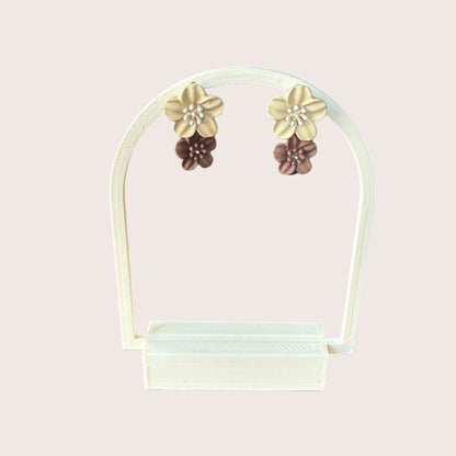 Nitelief double flower earrings in beige and brown with pearl centers displayed on a white stand