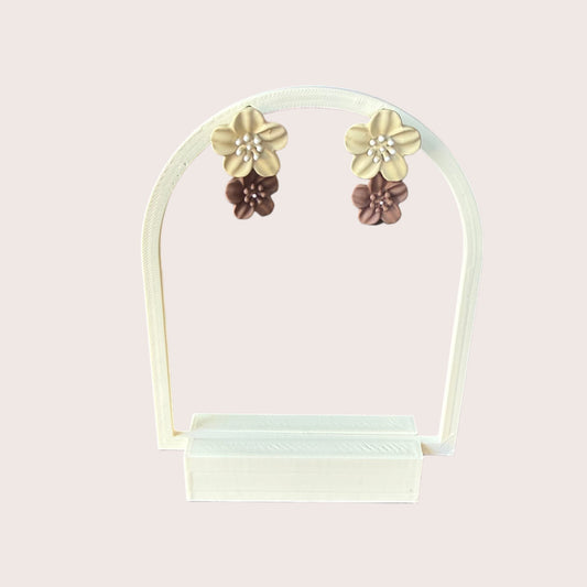 Nitelief double flower earrings in beige and brown with pearl centers displayed on a white stand