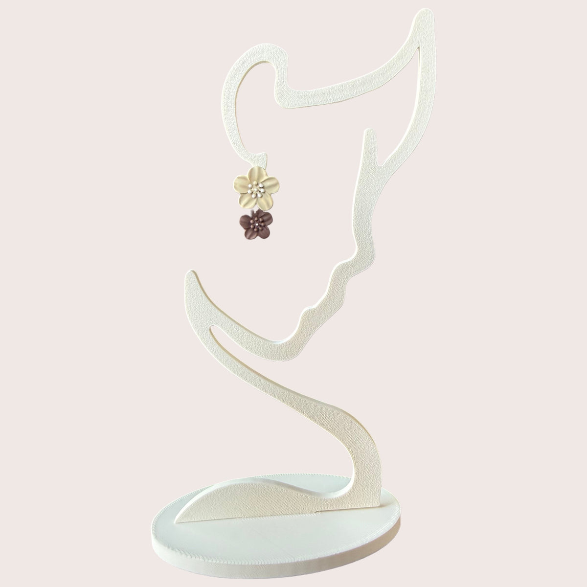 Nitelief double flower earrings featuring a cream and brown floral design on a white display stand