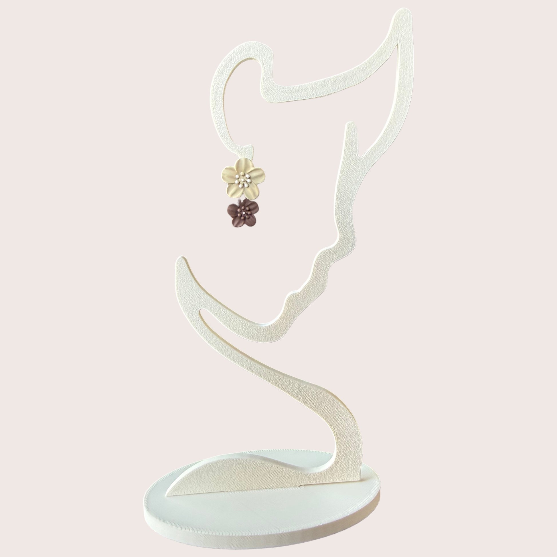 Nitelief double flower earrings featuring a cream and brown floral design on a white display stand