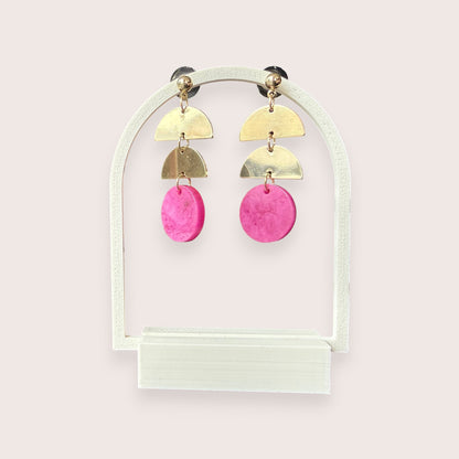 Nitelief gold-tone metal and pink resin geometric drop earrings on a white arch display stand