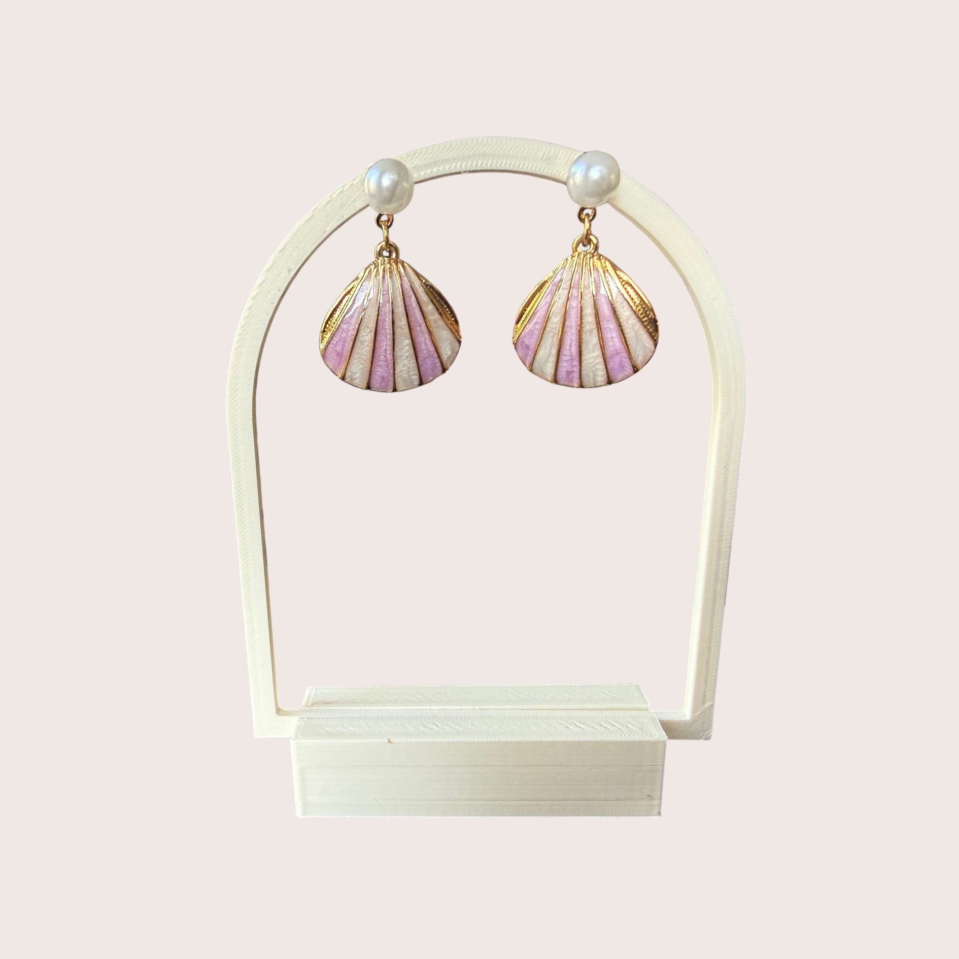 Nitelief Luna Pearl earrings featuring gold-tone stainless steel shell charms with soft pink enamel and small pearls.