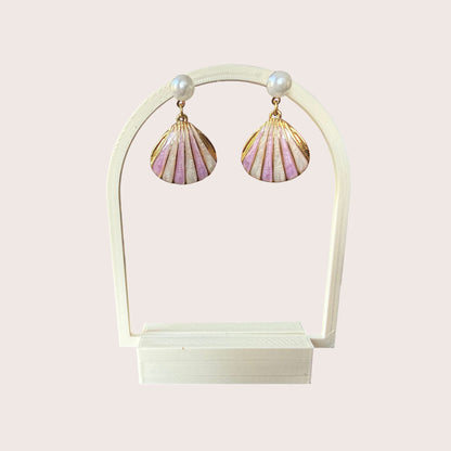 Nitelief Luna Pearl earrings featuring gold-tone stainless steel shell charms with soft pink enamel and small pearls.