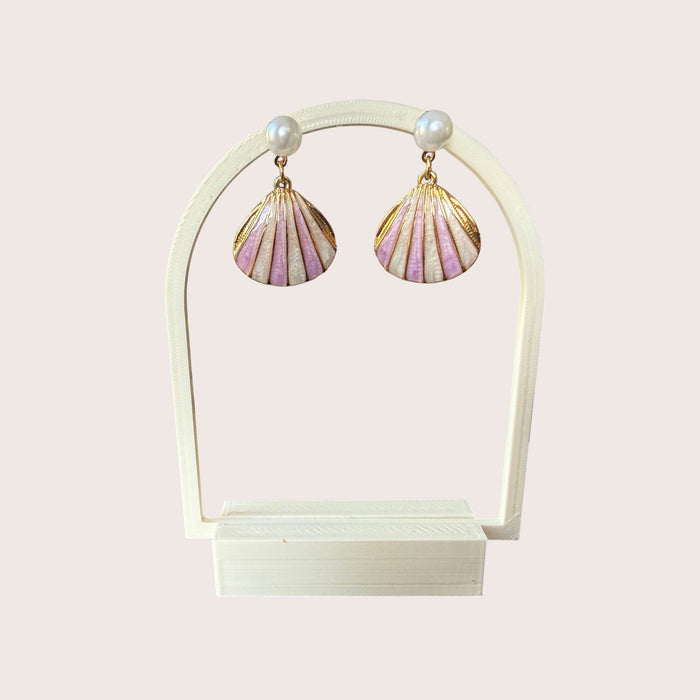 Nitelief Luna Pearl earrings featuring gold-tone stainless steel shell charms with soft pink enamel and small pearls.