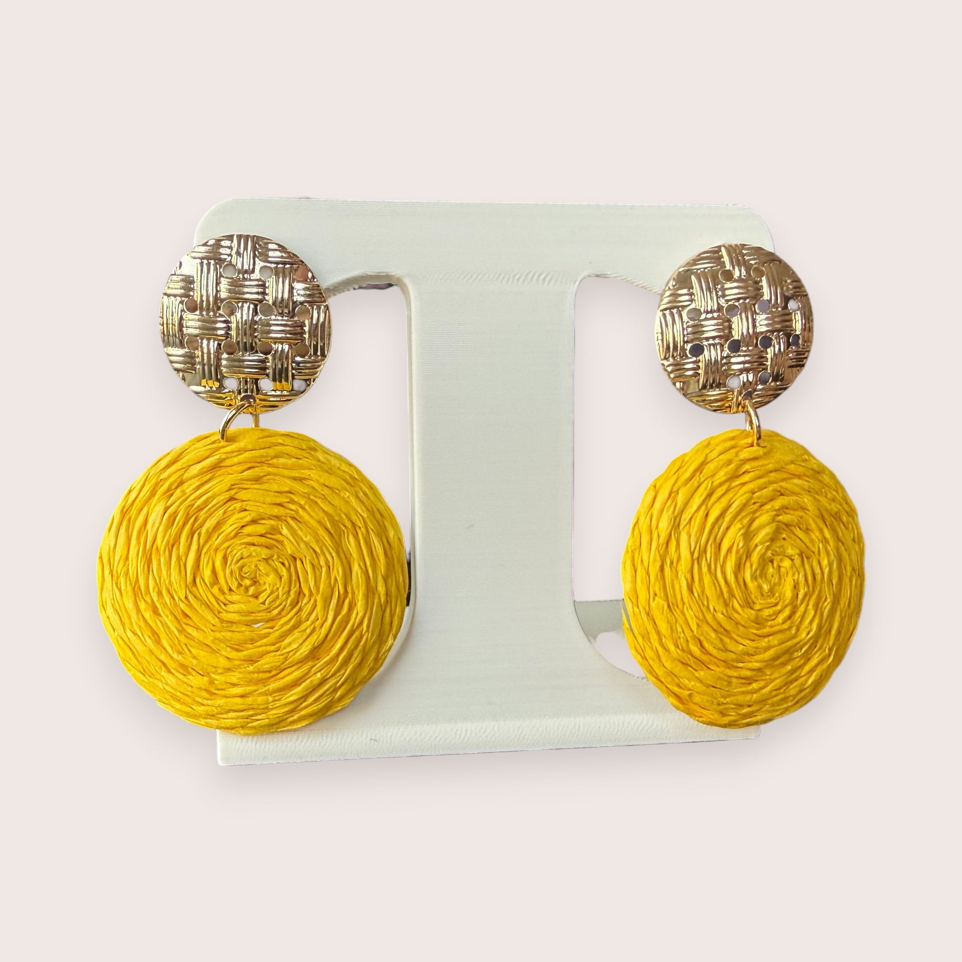 Nitelief CONCEPT Zonnetje earrings featuring round yellow raffia discs hanging from textured gold-tone metal studs.