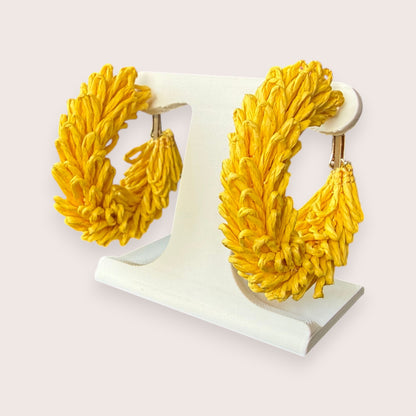 Nitelief CONCEPT Volle maan lightweight yellow raffia hoop earrings on a white display stand